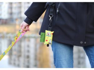 Practical dog poop bag holder attached to a leash, featuring vibrant sublimation printing and a secure carabiner clip.